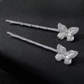 Detailed view of silver butterfly hair clips with textured metal wings on black leather - Small Silver (1 pair)