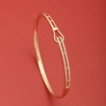 Brazalete de oro rosa con cierre de herradura y microcirconitas en fondo rojo - SZ02152 Diseño Hebilla Herradura Aprox 8.5g