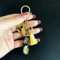 Detail of resin alphabet keychain with gold bee, white dried flowers and yellow tassel - Letter I