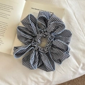 Chouchou surdimensionné à carreaux vichy noir et blanc avec bordure bleu clair sur livre - Carreaux Bleus