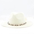 Close-up of bohemian straw hat featuring natural sea shells and ethnic beaded ribbon trim - Cream