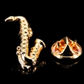 Dettaglio di una spilla a forma di sassofono dorato con finitura lucida su sfondo nero - Sassofono d'Oro