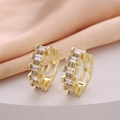 Elegant gold baguette and round zirconia hoop earrings on a soft pink satin fabric - Baguette Mixed Row