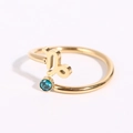 Dettaglio anello Capricorno dorato con gemma blu su sfondo bianco pulito e minimale - Capricorno - Oro