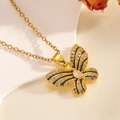 Detail of a gold butterfly necklace featuring black enamel trim and sparkling white zircon - Gold Black Pattern Bowknot Necklace