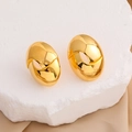 Dettaglio macro di orecchini ovali cavi placcati oro 18K su uno sfondo di pietra bianca - Placcato in Oro Vero 18K / Oro