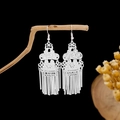 Detail view of silver tassel earrings with ethnic hollow patterns on a wooden branch - Vintage Hollow Tassel Style E2344