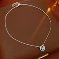 Dettaglio di una collana in argento con ciondolo di pietra blu su portagioie in pelle marrone - Collana d'Argento / Argento con Strass Bleu