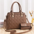 Bolso de mano marrón para mujer con acolchado en V y neceser a juego sobre mesa - Caqui