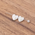 Détail macro de perles en nacre en forme de cœur avec lettre G dorée pour bijoux DIY - Lettre G