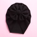 Close-up of a black baby turban hat with a large bow detail on a pink background - 18*21cm / Black