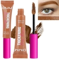 Macro shot of DNM thickening brow mascara brush with hair-like fibers and creamy texture - Auburn