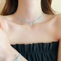 Gros plan d'un collier de perles bleues avec pendentif nœud scintillant sur modèle - Style Noeud Argenté Perles Bleues (46# Collier-Bleu)