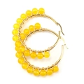 Detailed view of gold stainless steel hoop earrings with hand-wrapped yellow crystal beads - Gold + Yellow Stone