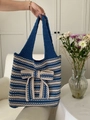 Detailed close-up of blue and white striped knit tote bag with large decorative bow - Sapphire Blue