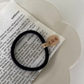 Détail d'un élastique noir sans couture avec étiquette en papier sur une assiette blanche - Sans Couture Haute Élasticité / Noir
