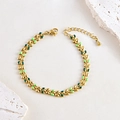 Bohemian gold wheat leaf bracelet with green enamel on a natural stone background - Cyan