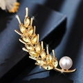 Elegant gold leaf brooch with yellow crystals and white pearl accent on dark blue texture - Golden Wheat Ear Pearl