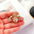 Dettaglio di una spilla a forma di ape barocca vintage con smalto colorato e strass di lusso - Bianco