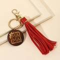 Detalle de llavero MAMA de madera con borla de cuero rojo y cierre de metal dorado - Rojo