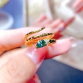 Macro shot of gold snake ring featuring a pear-cut green gemstone and scale texture - Green Pear Main Stone / Gold