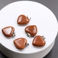 Five heart-shaped brown goldstone pendants with shimmering golden specks and silver clasps - Gold Sandstone