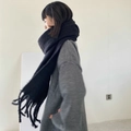 Soft faux cashmere black scarf with tassels worn by a model in a cozy winter style - Black