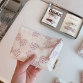 Close-up of small floral cotton coin purse with bow patterns and side brand tag - Light Purple Polka Dot Bow