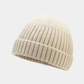 Detailaufnahme der cremeweißen Rippstrick-Textur und des Umschlags der warmen Beanie - Beige