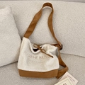 Dettaglio della borsa tote in lana d'agnello color crema con cuciture marroni e ricamo - Cachi