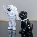 White astronaut figurine paired with a black pug statue in a white studded collar - Small Plated Silver Model A + Black Dog
