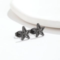 Detailed close-up of matte black hollow star stud earrings with a minimalist geometric design - Star Black