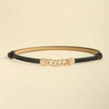 Détail d'une ceinture fine en cuir avec boucle en chaîne dorée et détails ronds en relief - Noir