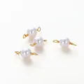 Detail von vier weißen Perlenverbindern mit vergoldeten Doppelschlaufen für DIY-Schmuck - 5mm