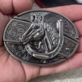 Detail view of a vintage western belt buckle with carved horse head and horseshoe - Stable Horse Head
