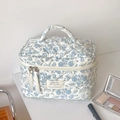 Blue floral quilted makeup bag with handle and dual zippers on white background - Blue Crabapple Flower Makeup Bag