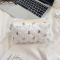 Detail of quilted white makeup bag with brown bear pattern and beige zipper on soft fabric - Small Grey Elephant