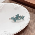 Detail of silver butterfly hair clip with turquoise rhinestones on vintage tray - Double Butterfly / Green