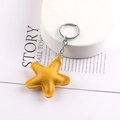 Close-up of yellow star-shaped leather keychain on a book for DIY bag decoration - Yellow