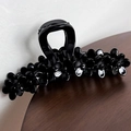 Dettaglio di una grande molletta per capelli nera da 13cm con motivi a fiori lucidi - Nero