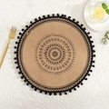 Round jute placemat with black mandala print and tassel fringe on a white tablecloth - Black Pom-poms Pattern 3