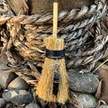 Close-up of mini wicca straw broom with silver pentagram and black crystal pendant - Pentagram with Black Crystal