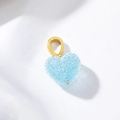Ciondolo a cuore azzurro scintillante con gancio dorato su sfondo bianco materico - Blu