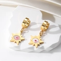 Close-up of golden star drop earrings with pink evil eye on white silk fabric background - Star Pink Eye