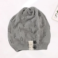 Close-up of gray knitted beanie with hollow-out leaf patterns and lace button detail - Adjustable / Light Gray