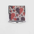 Close-up of folding makeup mirror with sparkling red, purple, and white rhinestones - Heart