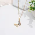 Detalle del colgante de lazo dorado con circonitas e incrustación degradada azul - Mariposa con Degradado de Color Dorado
