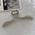 Dettaglio ravvicinato di un fermaglio per capelli in argento con strass e cuore - Stile Con Strass Completo