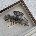Close-up of a high-quality acrylic hair claw with vintage black mesh patterns and golden spring - Sycee / Ingot / Black