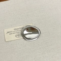 Macro detail of silver pebble brooch with mirror finish on grey linen fabric - 10 Oval Silver (Z-3660)